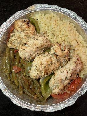 Delicious chicken kabobs with sides of green beans and rice