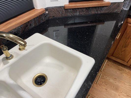 New slab top with gold flecks that match faucet and cabinet handles.