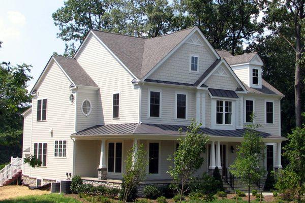 Dimensional shingle roof with standing seam metal accents on porches and returns