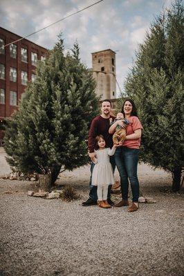 a family of four stand by the Mckinney Mill and pose for a picture at their family photography session