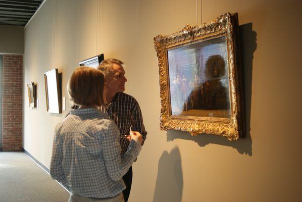 Sergei Voblikov and paintings conservator Sofia discussing the painting of Dirck Hals.