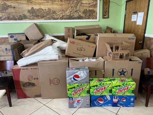 Junk, drinks, and containers, piled in front of a non-working restroom.