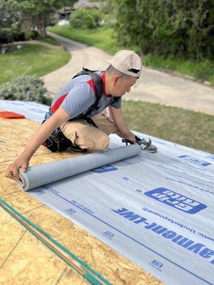 Rolling out felt for a shed roof, lined up neatly