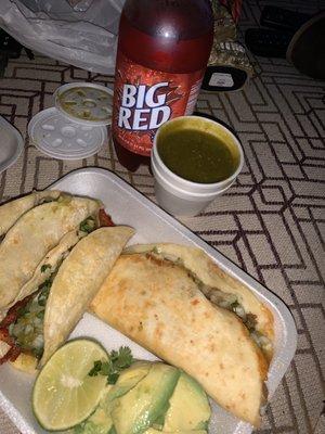 Una quesadilla de carne asada un taco de al pastor otro taco de barbacoa y un vasito de salsa verde con una Big red