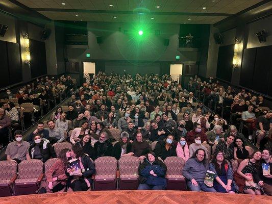 A full theater on Valentine's Day -- kissing, waving, smiling, and crushing popcorn from the audience.