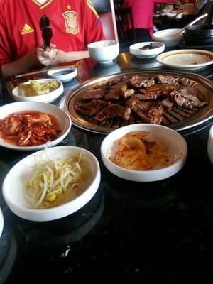 Marinated beef slices and beef short ribs. Dishes around grill come with meal