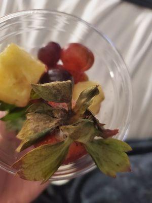 The fruit cup with old pineapple, browned apples, and moldy strawberries.