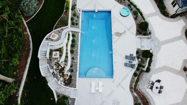 Full view of a new custom in-ground pool, featuring a slide, laminars, and more!