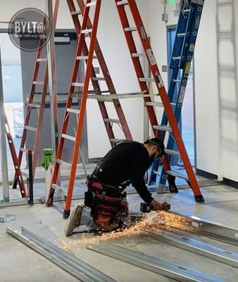 BYLTup technician cutting and installing steel framing for interior wall at Dr. Robb Farms cultivation facility in Desert Hot Springs, CA.