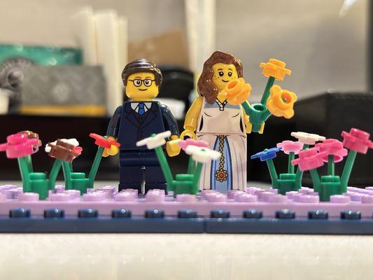 Bride and groom minifigs with an extra pack of flowers and Lego pieces.