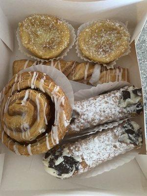 My goodies! Cannolis, cinnamon roll, cinnamon twist, custards