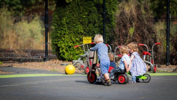 Three toddlers play together in our outdoor playground area.