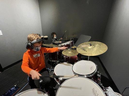 A couple of birthday party friends jamming on the drums in one of our lesson rooms.