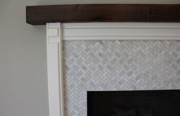 Herringbone mosaic marble tile on fireplace