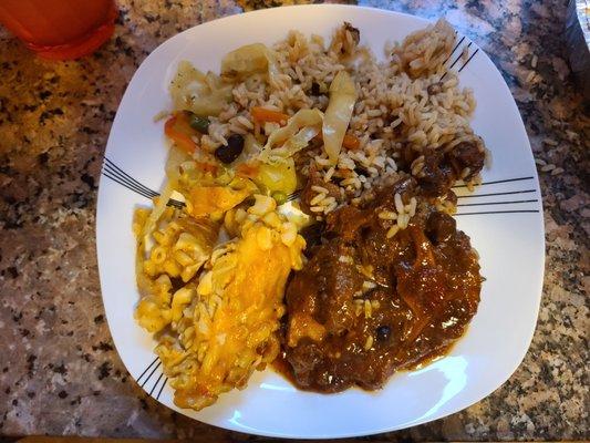 Ox tail, Mac and Cheese, fried cabbage and rice and beans