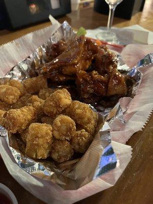 Teriyaki chicken wings with tots.