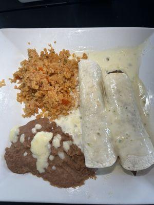 Enchiladas (one grilled chicken, one steak) in a cheese sauce with rice and beans