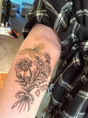 Yellow butterfly with black and gray flowers tied in a bouquet by Caitlin.