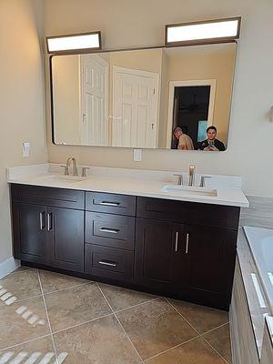 New cabinets and countertops installed with new mirror and lights