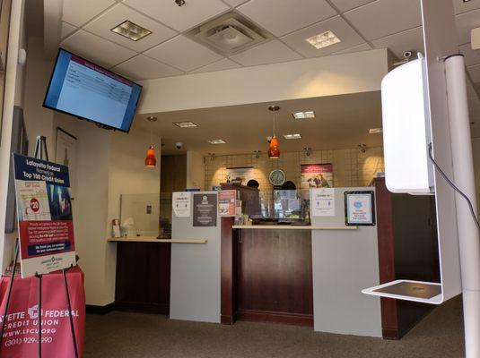 Lobby and service counter viewed from waiting area with hand sanitizer station