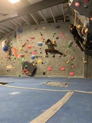 Several people climbing slab in progression climbing gym