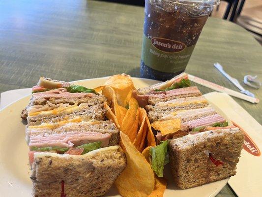 The Club Sandwich with barbecue chips and soda.