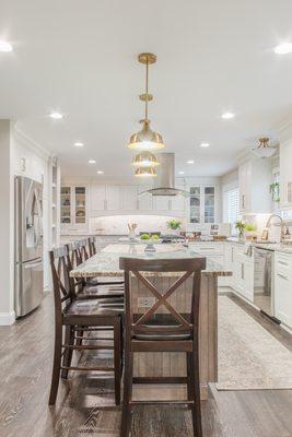 White with elegant brushed bronze accents. Our designers did an amazing job opening this space up and giving our client their dream kitchen.