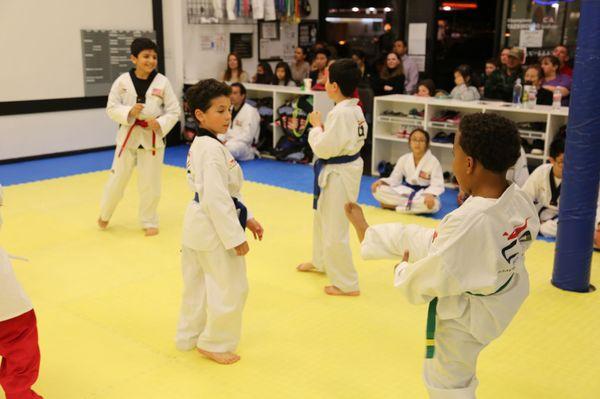 Practicing their kicking techniques during free sparring in class.