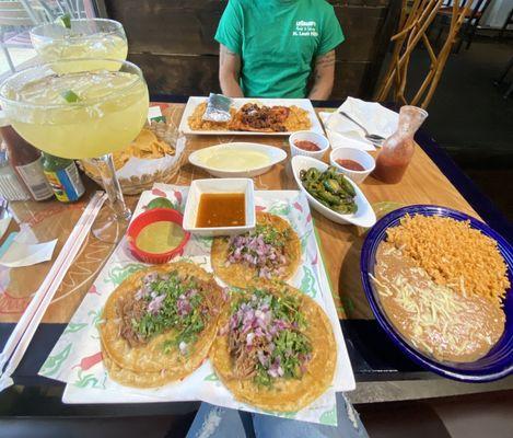 Tacos de birria, pollo con chori, jumbo margaritas, queso, salsa, grilled jalapeños, rice and beans