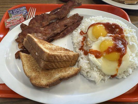 Breakfast plate: rice, eggs, bacon, toast and my hot sauce!