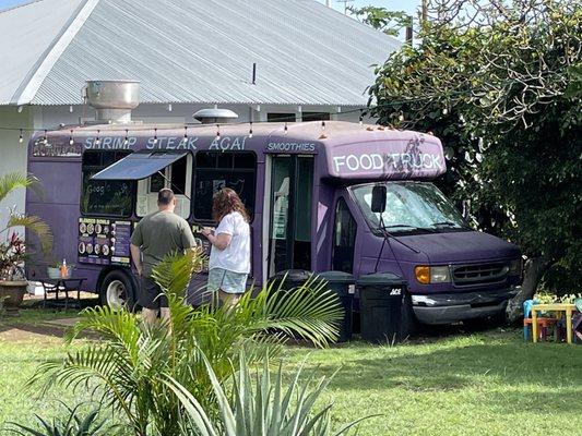 Look for the purple food truck in between two cute houses in a neighborhood.