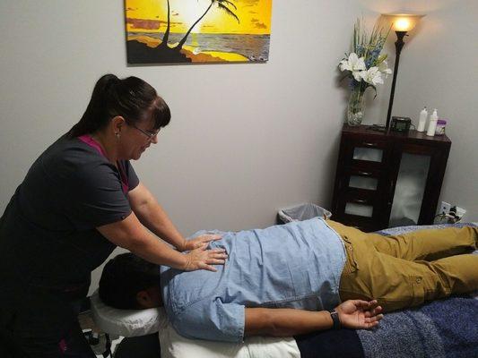 Certified Massage Therapist, Linda, releasing a patient's tension and muscle tightness.