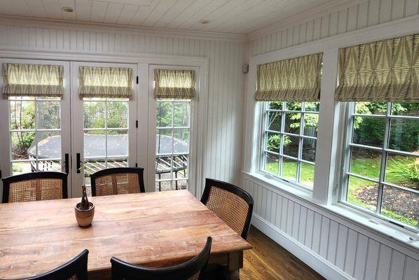 Custom roman shades can dramatically change a space.  Here a warm block printed fabric compliments the flooring and furniture selections.