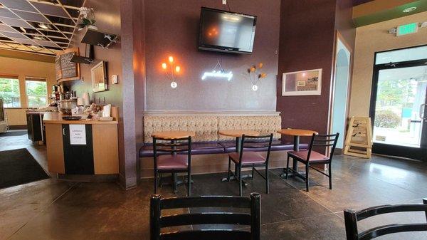 One of the seating areas, to the left is the counter area and to the right is an exit. The restrooms are located next to the exit.