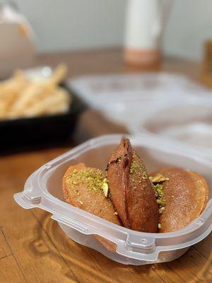 Quataif, a Syrian dessert. Spongy, filled, dipped in syrup, and topped with pistachios. Absolutely decadent.