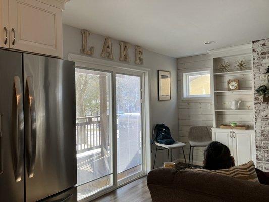 Living room with sliding door right onto patio with view of lake.