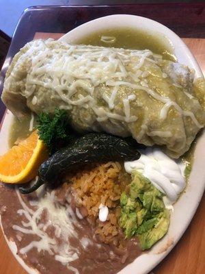 Wet burrito asada in green sauce with beans and rice.