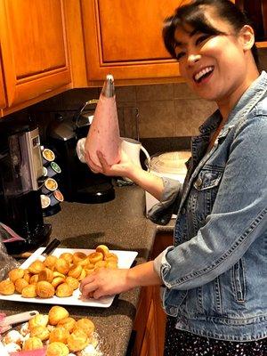 Filling the mini cream puffs by the Caker