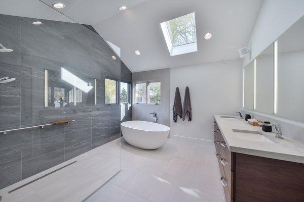 Modern spa-like bathroom with curb-less shower, spa tub, modern vanity and fixtures.