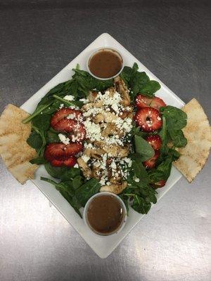 Grilled chicken and strawberry salad with fresh spinach and goat cheese. Drizzled with balsamic vinaigrette