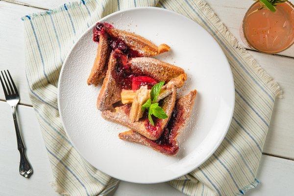 Churro French Toast-thick brioche, cinnamon sugar, berry coulis, topped with powdered sugar.