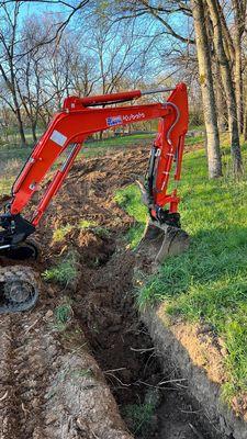 Flawlessly got the old water main out and new trench put in along this 600' tree line.