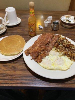 Three eggs over easy, corned beef hash and crispy hash browns With 2 small pancakes for bread substitute.