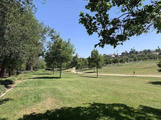 Abdullah Park showing trees, soccer fields and walking path.