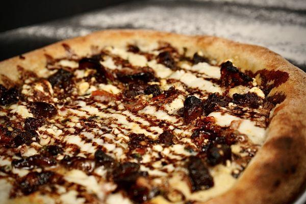 The Sweet Swine - Garlic infused EVOO, garlic, hand-pulled mozzarella, sweet pork belly, goat cheese, roasted tomatoes, balsamic reduction.