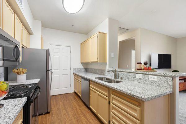 Modern kitchen with granite counters and stainless steel appliances.