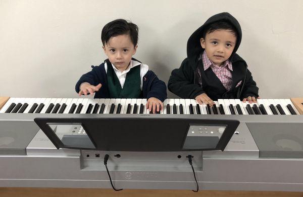 Nehemiah (left) and brother Elijah learning to play piano for God's glory.