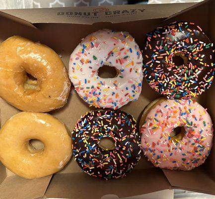 2 glazed, 1 vanilla, 2 chocolate and 1 strawberry with sprinkles on them.