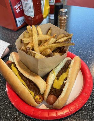 two chili dogs, mustard and onions and fries