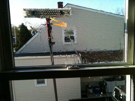 Residential window cleaning equipment at work from inside a Long Island home